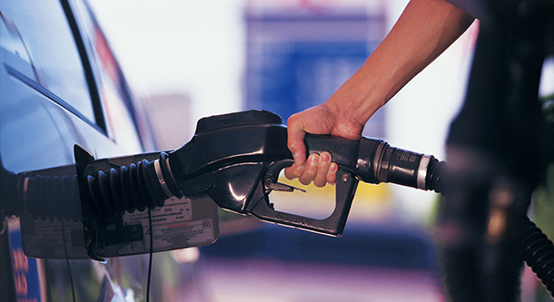 person fueling up as gas prices fall again