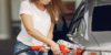 falling gas prices at the pump as woman pumping gas