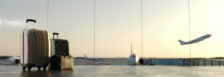 suitcases at airport with plane taking off in distance